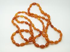 An amber necklace of 80 ovoid egg yolk coloured beads, each approximately 11x7mm, 22g, 100cm long.