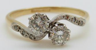 An 18ct gold ring set with two round cut diamonds each measuring approximately 0.