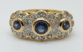 An 18ct gold ring set with three round cut sapphires surrounded by diamonds (size O)