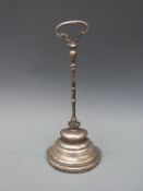 A Georgian polished steel door stop or porter,