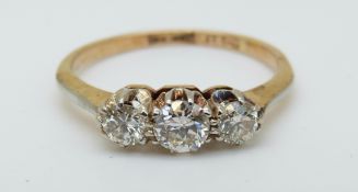 An 18ct gold ring set with three diamonds in a platinum setting, the centre diamond approximately 0.