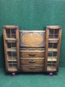 A carved oak side by side bureau bookcase with leaded glass doors
