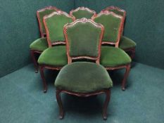 A set of six stained walnut dining chairs upholstered in green dralon