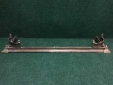 An antique brass fire curb