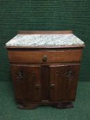 A continental oak double door marble topped bedside cabinet