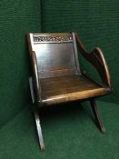 An early twentieth century carved armchair on x-framed support