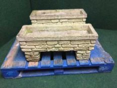 A pair of stone brick plant troughs on stands