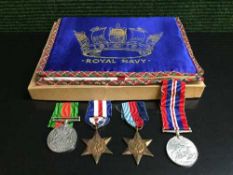 A collection of four WWII medals with ribbons and a box of Royal Navy embroidered pouch