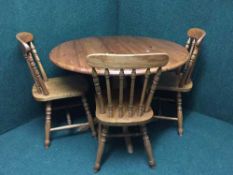 A pine kitchen table and three spindle back chairs