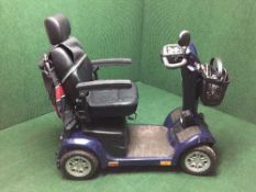 A Pride mobility scooter with keys and charger,