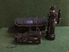 A crate containing Cannon video cam corder, Celeston Rom spotting scope together with a camera bag,