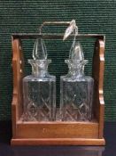 A mahogany two decanter tantalus with silver plated handed with key