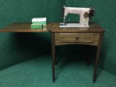 A Singer electric sewing machine in mahogany table