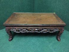 An Oriental carved low table with plate glass top