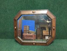 An early 20th century octagonal oak framed mirror