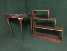 A walnut pie crust edge d-shaped table and a set of oak graduated shelves