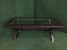 A brown leather and glass topped coffee table