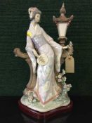 A Lladro figure of a Geisha on wooden plinth