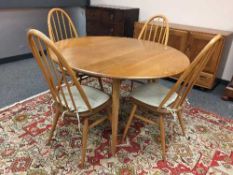 An Ercol light elm drop leaf dining table and four chairs