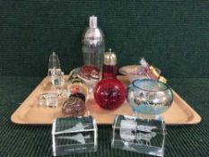 A tray of cranberry glass sifter, glass paperweights, cocktail shaker etc.