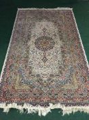 A cream silk finished fringed Persian rug