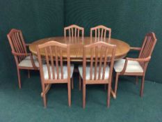An oval teak extending table and six chairs