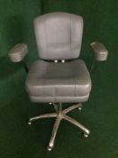A contemporary grey leather swivel armchair on chrome swivel base