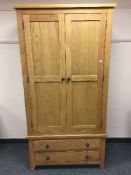 A contemporary light oak two door wardrobe