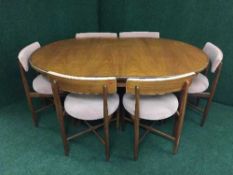 An oval teak G-Plan dining table and six chairs