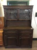 A carved oak kitchen dresser with leaded glass doors