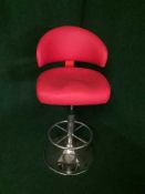 A contemporary red leather swivel bar chair