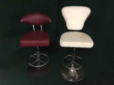 Two contemporary leather swivel bar stools on chrome bases (cream and red)