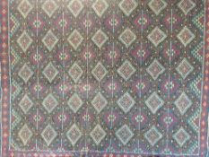 A fringed woolen Turkish rug with diamond pattern on blue ground