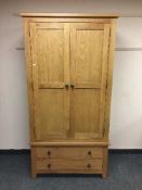A contemporary light oak two door wardrobe