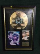 A framed Grease disc,