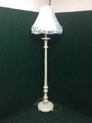 A carved painted standard lamp and shade