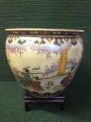 A large Japanese fish bowl planter with wooden stand