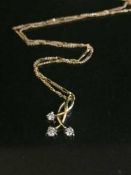 A 9ct gold three stone diamond necklace
