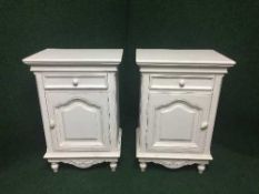 A pair of painted bedside cabinets fitted with a drawer