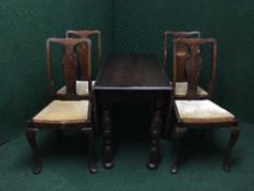 An oak drop leaf table and four Queen Anne style chairs