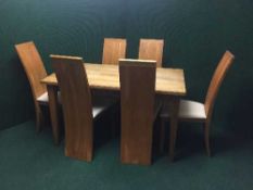 An oak dining table and six high backed dining chairs