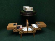 A circular mahogany leather topped drum table together with a concertina sewing box and a quantity