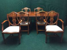 A yew wood twin pedestal dining table with leaf and six shield back dining chairs