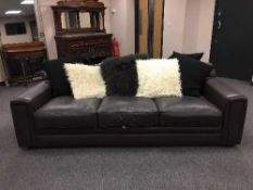 A pair of brown leather three seater settees with scatter cushions,