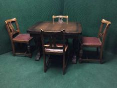 A heavily carved oak extending dining table and four chairs
