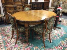 An Edwardian oak extending oval dining table,