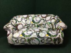 A two seater settee upholstered in contemporary fabric