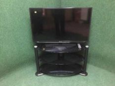 A Samsung 40 inch LCD TV on stand with remote