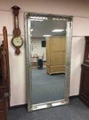 A tall silvered bevelled mirror,