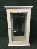 A counter topped painted glass door display case